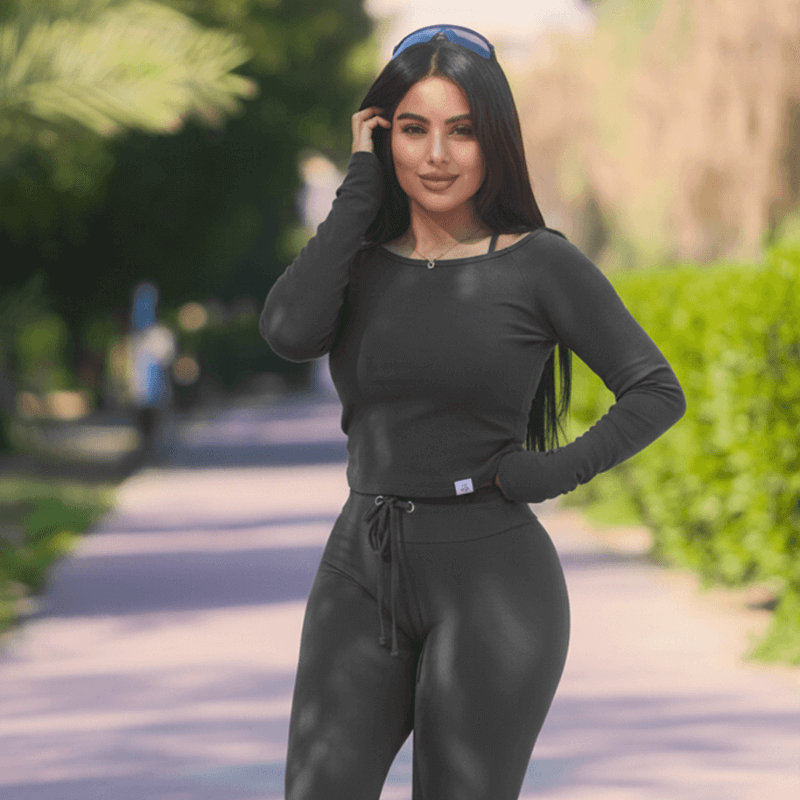 Fitness Coach Rawia of Body by Rawia standing at the gym beside weights labeled 5 kg and 10 kg